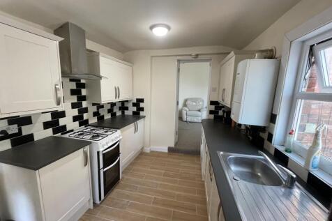 Bright modern galley kitchen with white cabinet...