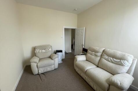 Bright, neutrally decorated living room with co...