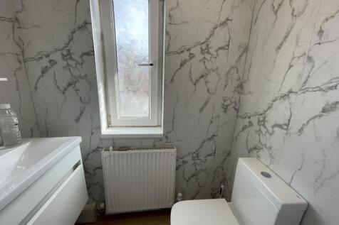 Bright, modern bathroom with marble-effect tile...