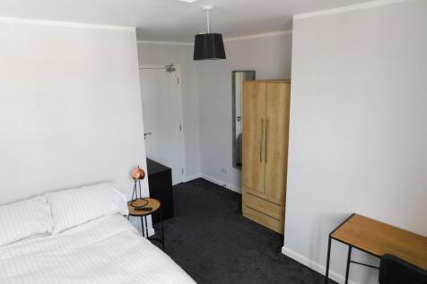 Bright and modern master bedroom featuring a co...