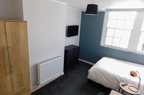 A bright and modern bedroom featuring a large w...