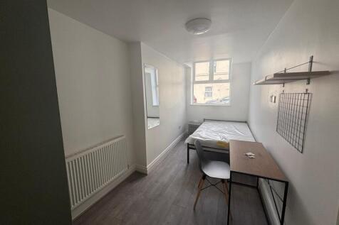 This cozy double bedroom features ample natural...