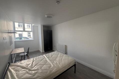Spacious double bedroom featuring large windows...