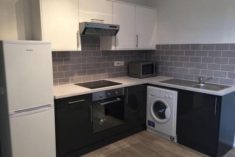 Modern kitchen featuring a white refrigerator, ...