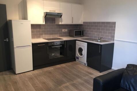 Modern kitchen area featuring sleek cabinetry, ...