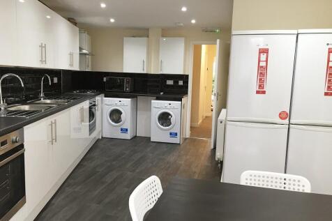 A modern, well-equipped kitchen with sleek whit...