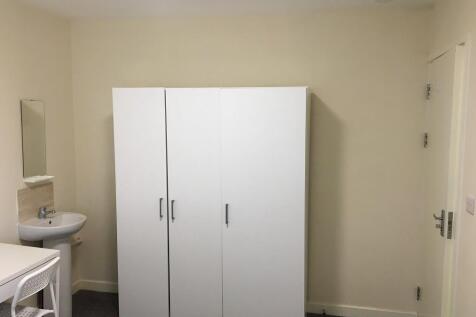 A neat and simple single bedroom featuring a wh...