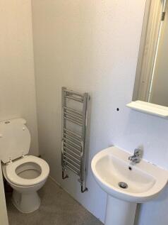 A clean and simple single toilet room featuring...