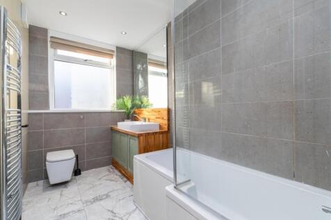 Bright, modern bathroom with a bathtub and inte...