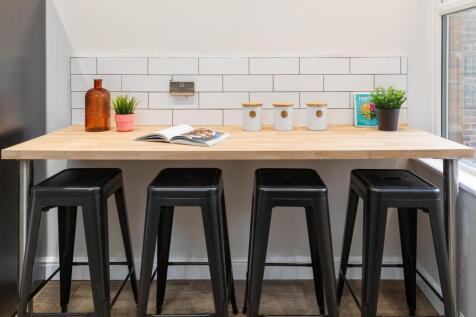 Bright modern kitchenette with a long wooden br...