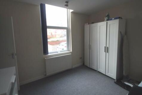 Bright, neutrally decorated bedroom with a larg...