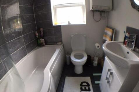 Bright fitted bathroom featuring a modern batht...