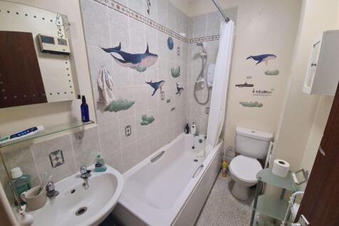 Bright, well-kept bathroom with a bathtub and s...