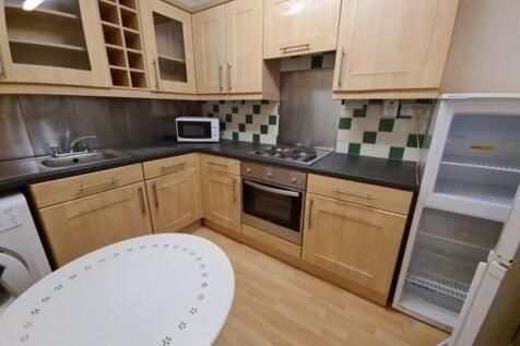 Well-equipped fitted kitchen with light wooden ...