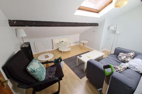 Bright, modern living area with sloped ceiling ...