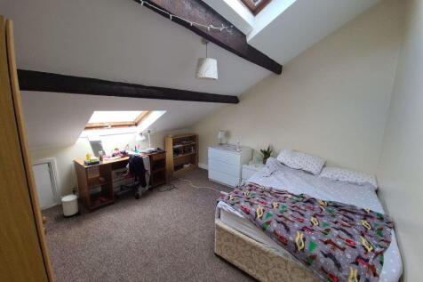Bright attic bedroom with sloped ceilings and e...