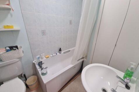 Bright, tidy bathroom with a bathtub and shower...