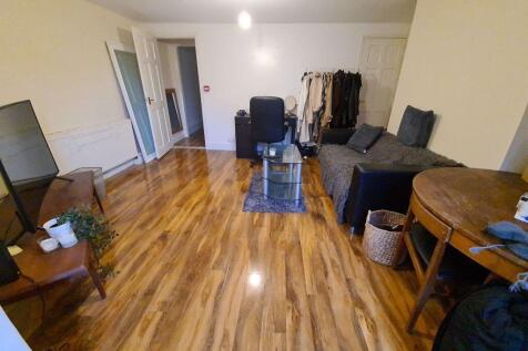 Spacious, open-plan living area with warm wood-...