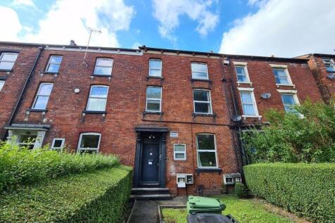 Red-brick terraced house with a neat front gard...