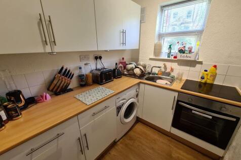 Well-equipped kitchen with light wood worktops,...
