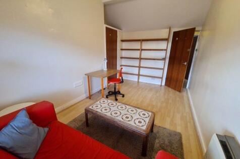 Bright furnished bedroom with a red sofa, patte...