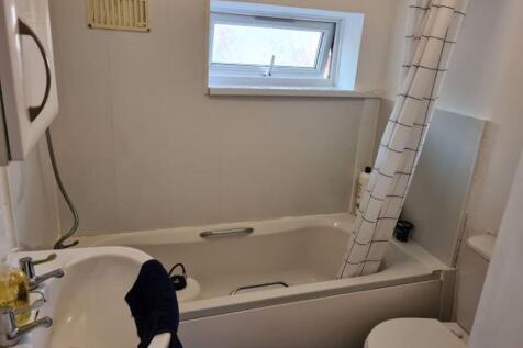 Compact, tidy bathroom with a bathtub, shower c...
