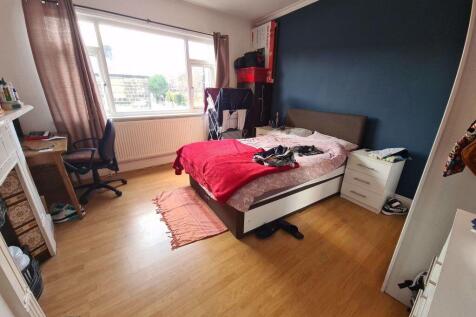 Bright double bedroom with a large window, wood...