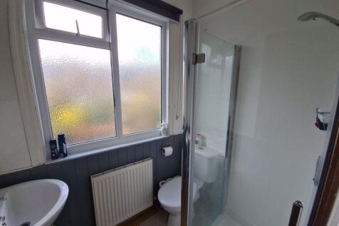 Bright, modern bathroom with a corner glass sho...