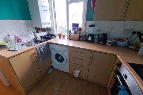 Bright galley-style kitchen with wood-effect ca...