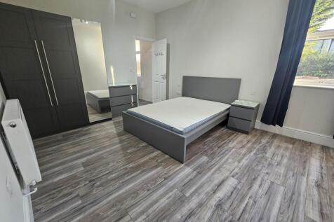 Bright, modern double bedroom with a large wind...