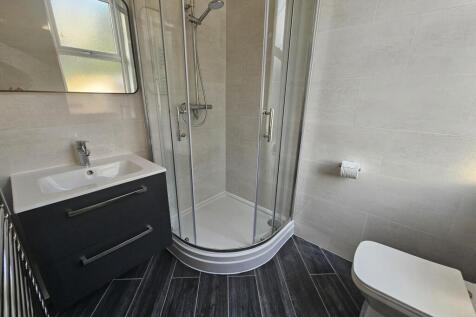 Modern bathroom with a curved glass shower encl...