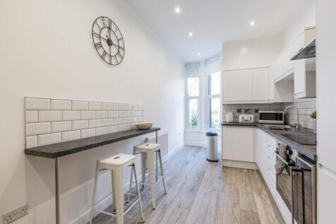Bright modern galley kitchen with wood-effect f...