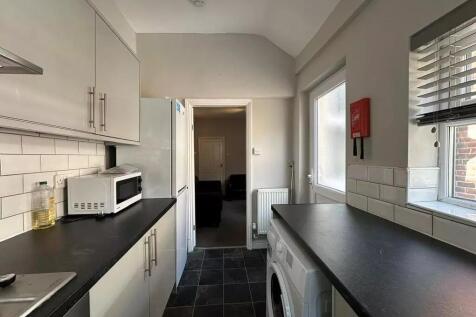 Bright and clean kitchen featuring modern white...