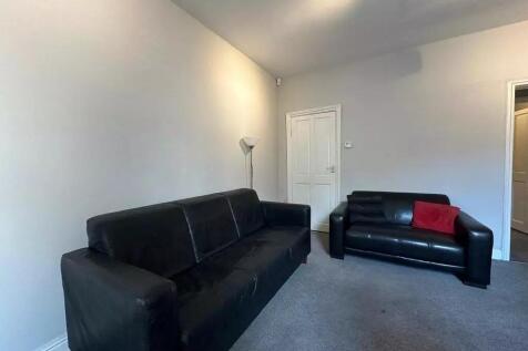 A cozy living room featuring two black sofas on...