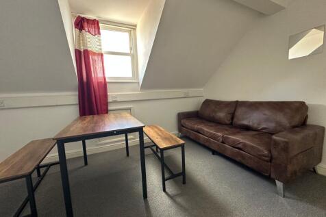 A cozy living room featuring a rich brown leath...