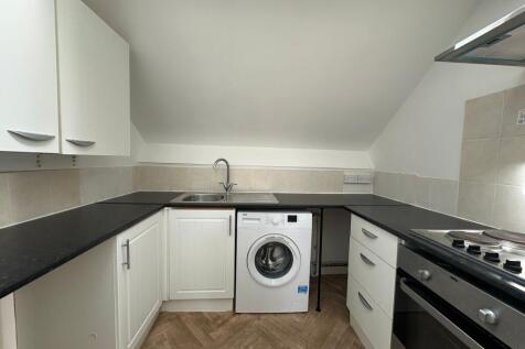 A neat and functional kitchen featuring clean b...