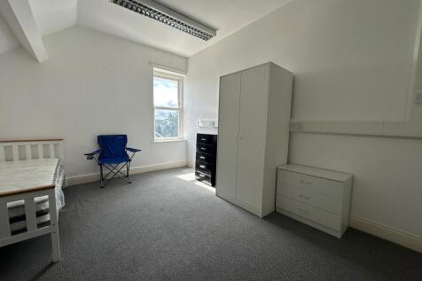 A bright and tidy bedroom featuring a single be...