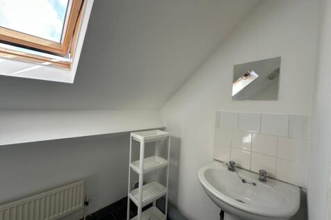 A clean, modern bathroom featuring a white sink...
