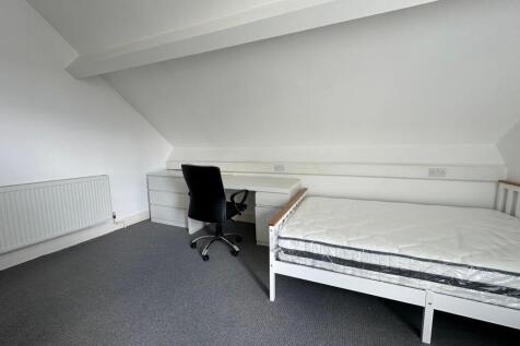 A clean and simple single bedroom featuring a w...