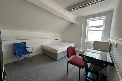 Bright single bedroom with a comfortable bed, a...