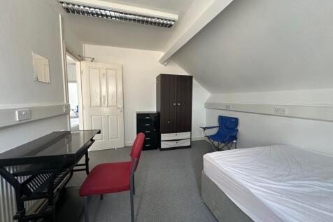 A neat and simple single bedroom featuring a co...