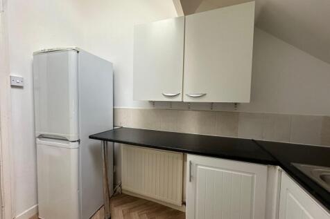 A compact kitchen featuring a clean black count...