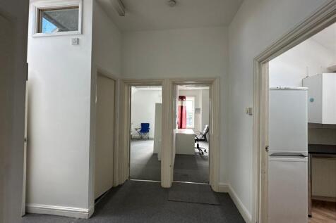 A clean and well-lit hallway featuring multiple...