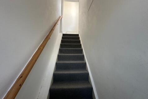 A well-maintained indoor staircase with a woode...