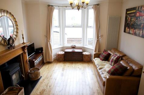 This spacious living room features large bay wi...