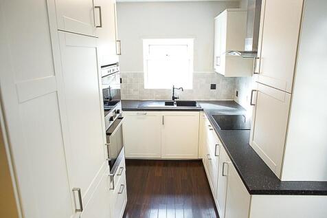 Modern kitchen featuring sleek cabinetry, ample...