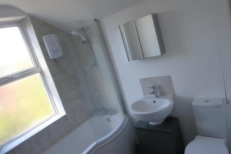 Bright and modern bathroom suite featuring a cu...