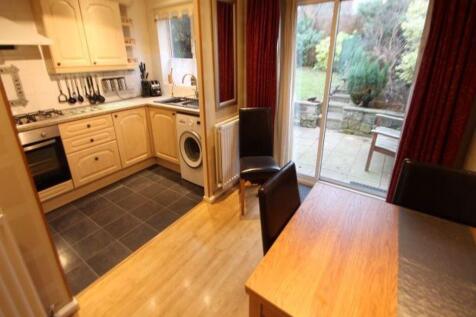 Bright open-plan kitchen with wooden cabinetry,...
