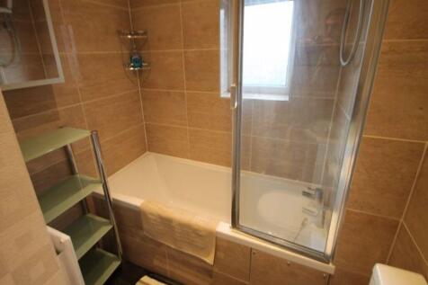 Bright, modern bathroom with tiled walls, combi...