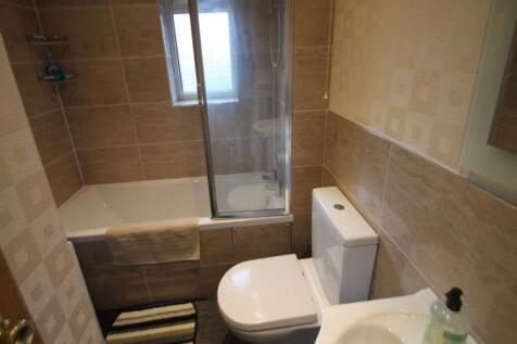 Well-presented bathroom with tiled walls, a com...